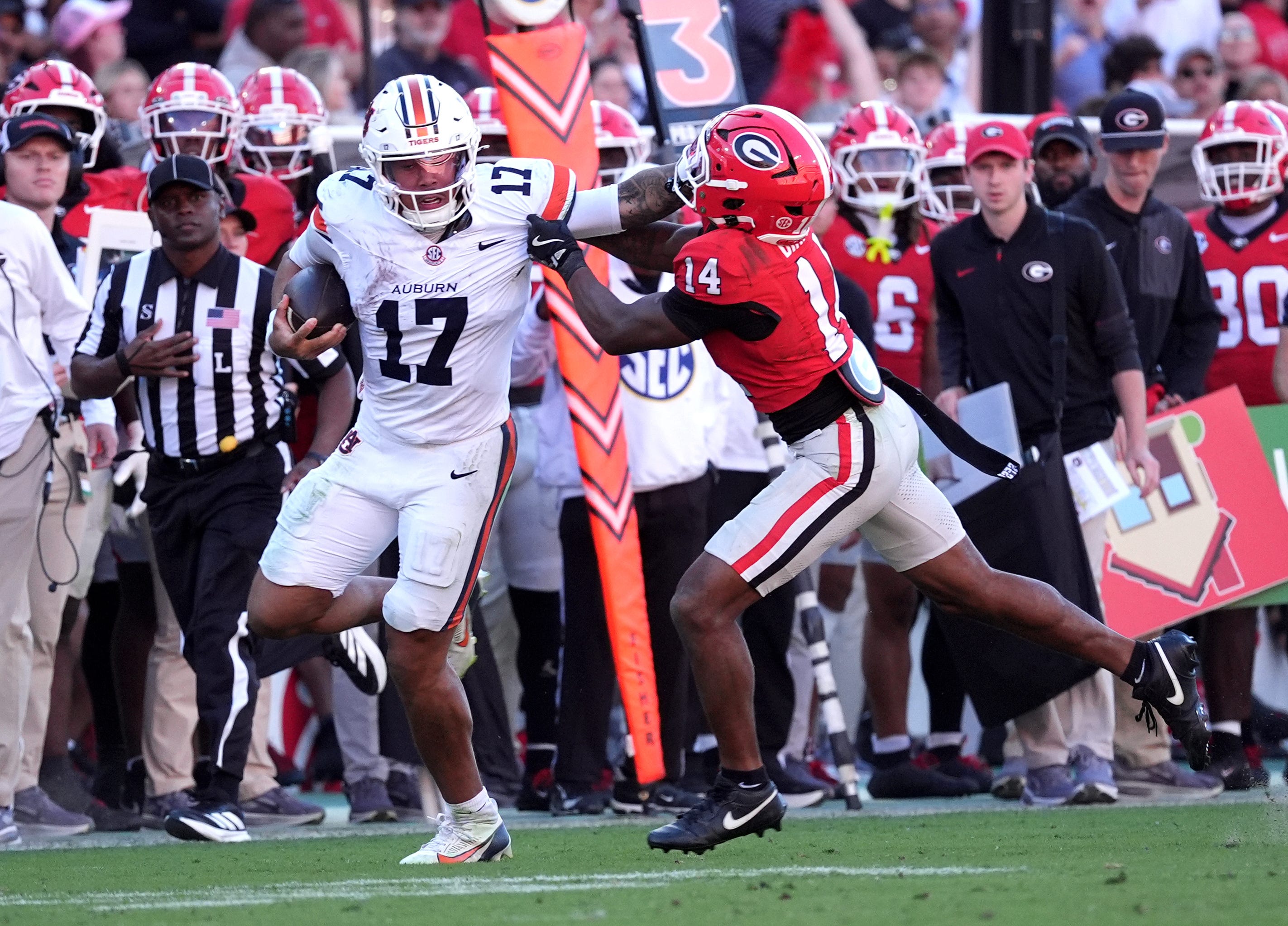 Auburn quarterback Byrum Brown (17) runs for a gain past Georgia safety Rasean Dinkins (14) during the third quarter at Sanford Stadium.