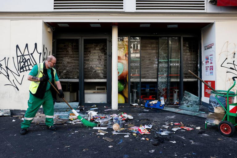 A worker cleans a street the day after clashes during a national day of demonstrations against the cost of living and rising fuel prices, in Paris, France, October 18, 2026. REUTERS/Benoit Tessier