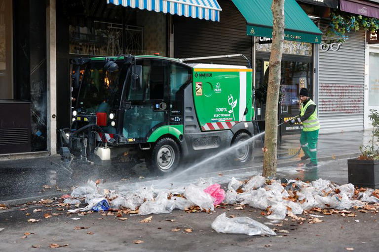 A municipal worker cleans a street a day after clashes during a national day of demonstrations against the cost of living and rising fuel prices in Paris, France, October 18, 2026. REUTERS/Benoit Tessier