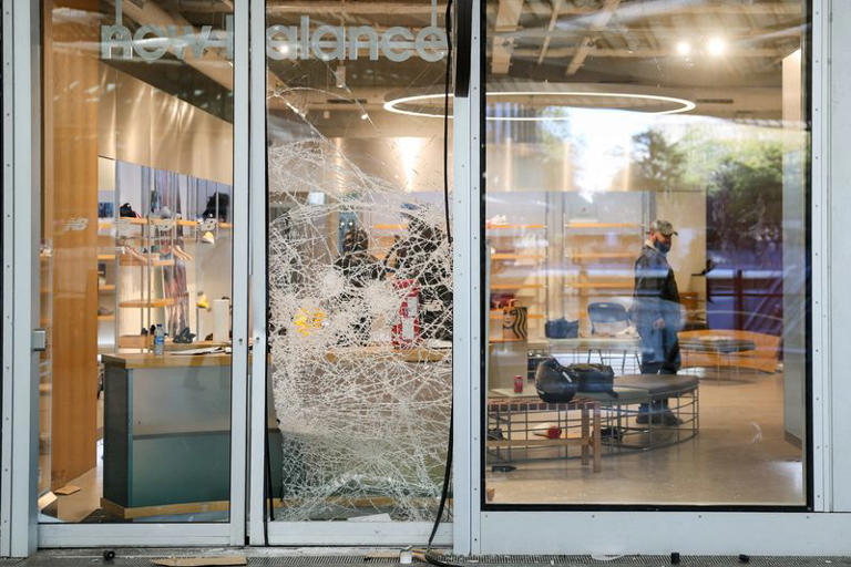 A man stands inside a vandalised New Balance store, the day after clashes during a national day of demonstrations against the cost of living and rising fuel prices, in Paris, France, October 18, 2026. REUTERS/Stephanie Lecocq