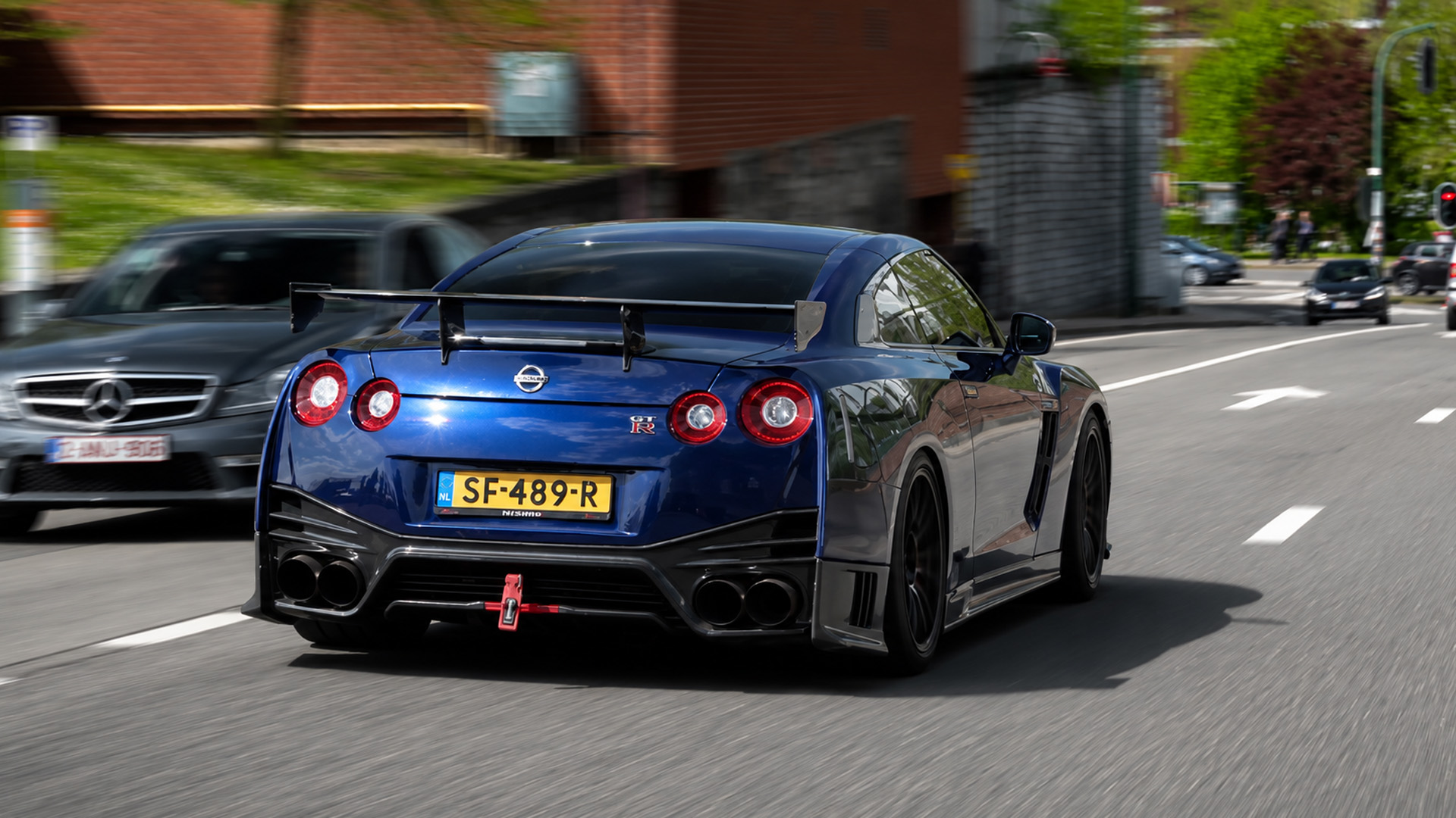 A deep blue Nissan GT-R R35 makes a thunderous pass on the street