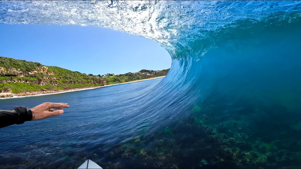 Surfer paddles out alone at a clean reef break