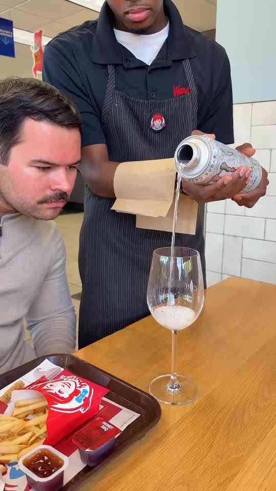 Fast food employee pours energy drink at restaurant