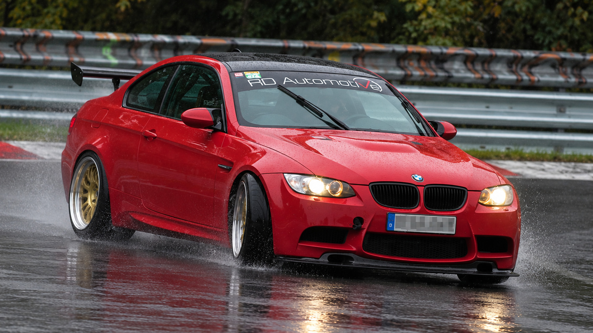 Several cars run wide as rain covers the Nordschleife