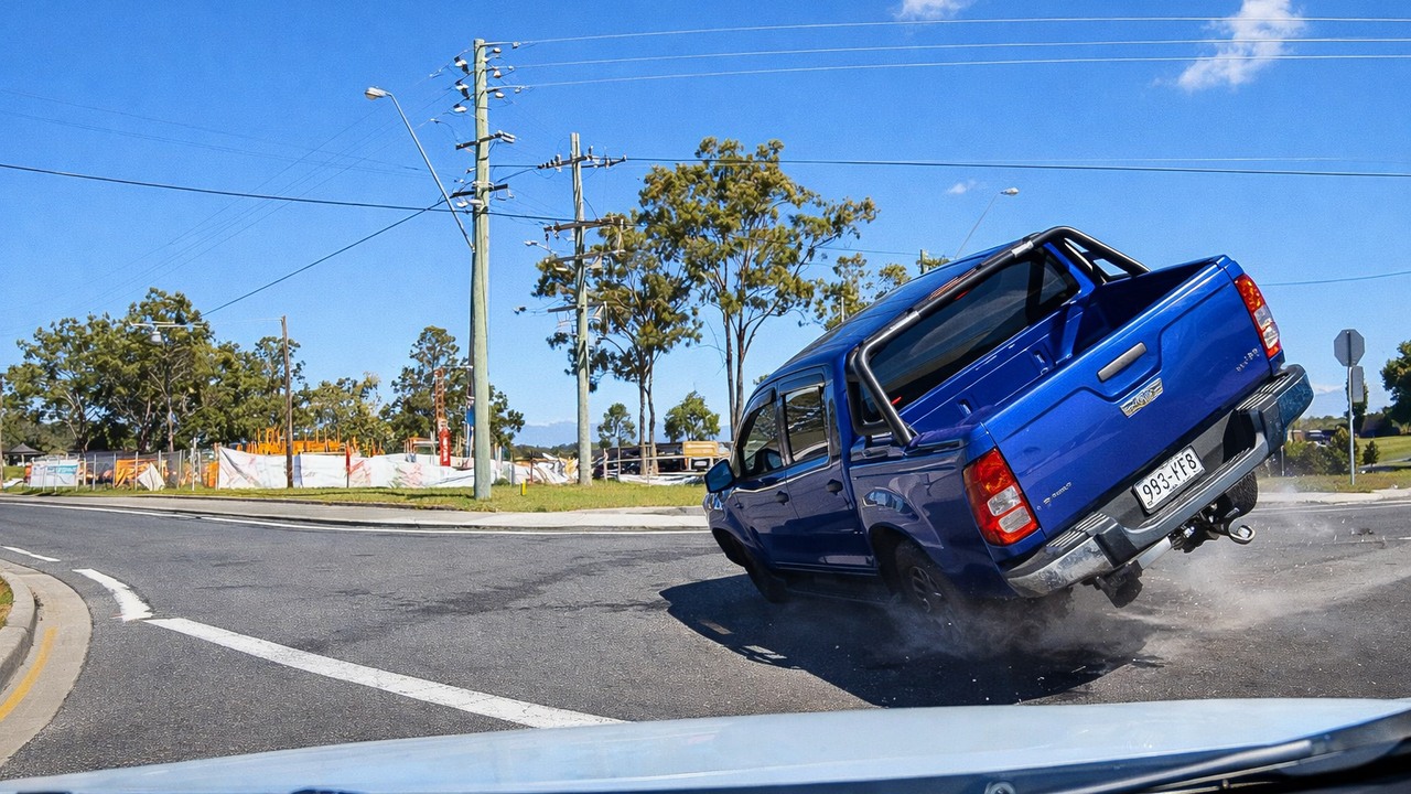 A blue truck gets hit by a red-light runner - and ends up on its side
