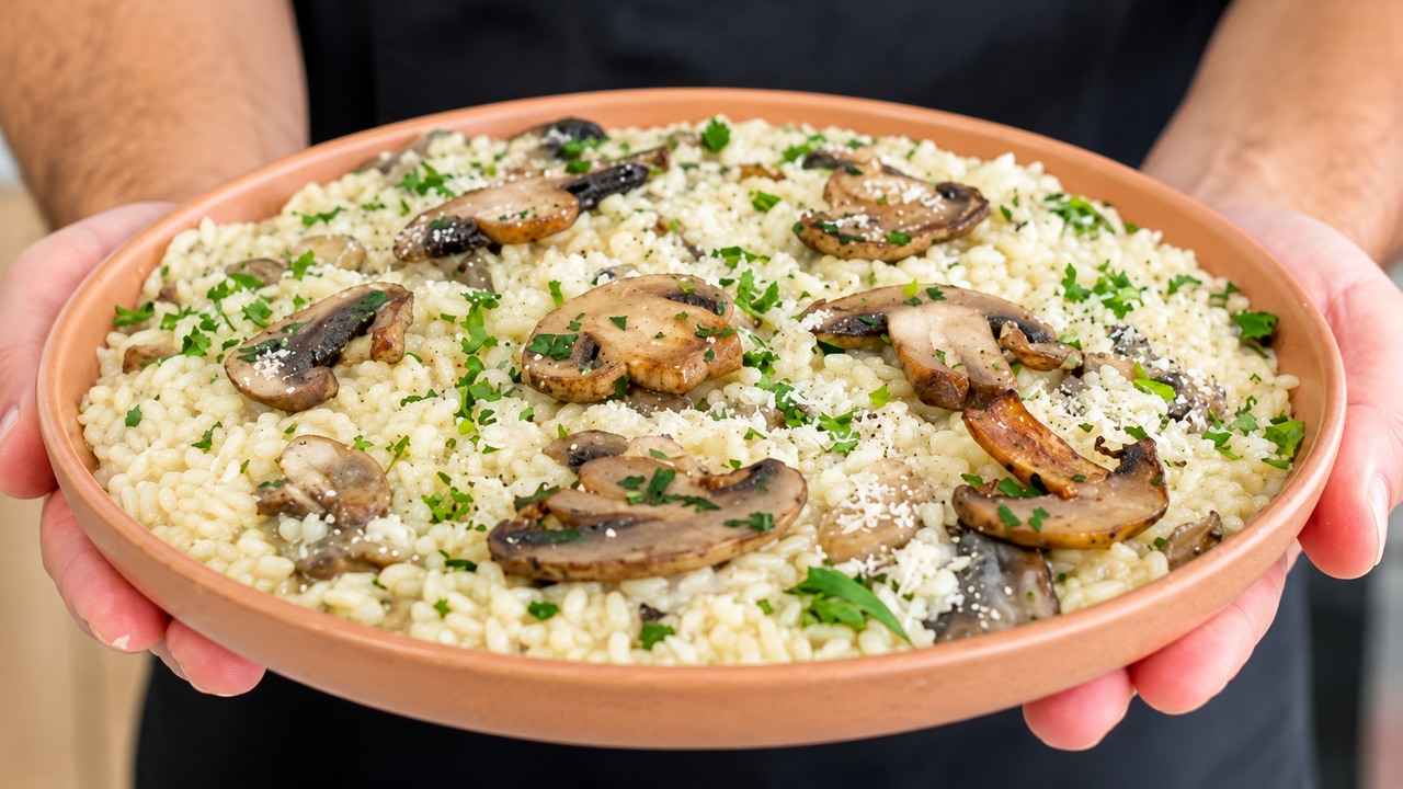 An Italian chef finishes mushroom risotto after turning off the heat