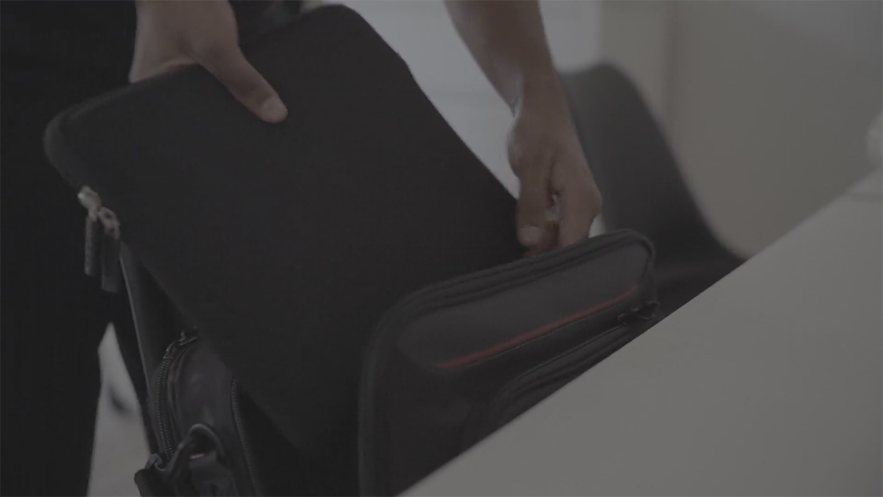 Packing a laptop into a protective bag before leaving