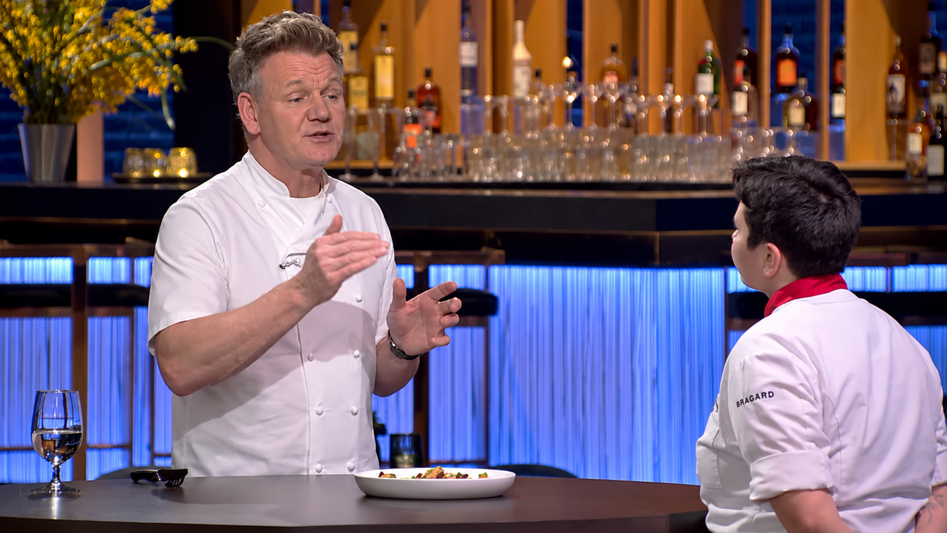 Chef Ramsay hands Alejandro a black jacket for lobster ravioli twist