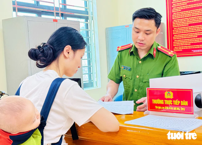Cán bộ công an hướng dẫn công dân thực hiện thủ tục hành chính - Ảnh: DANH TRỌNG