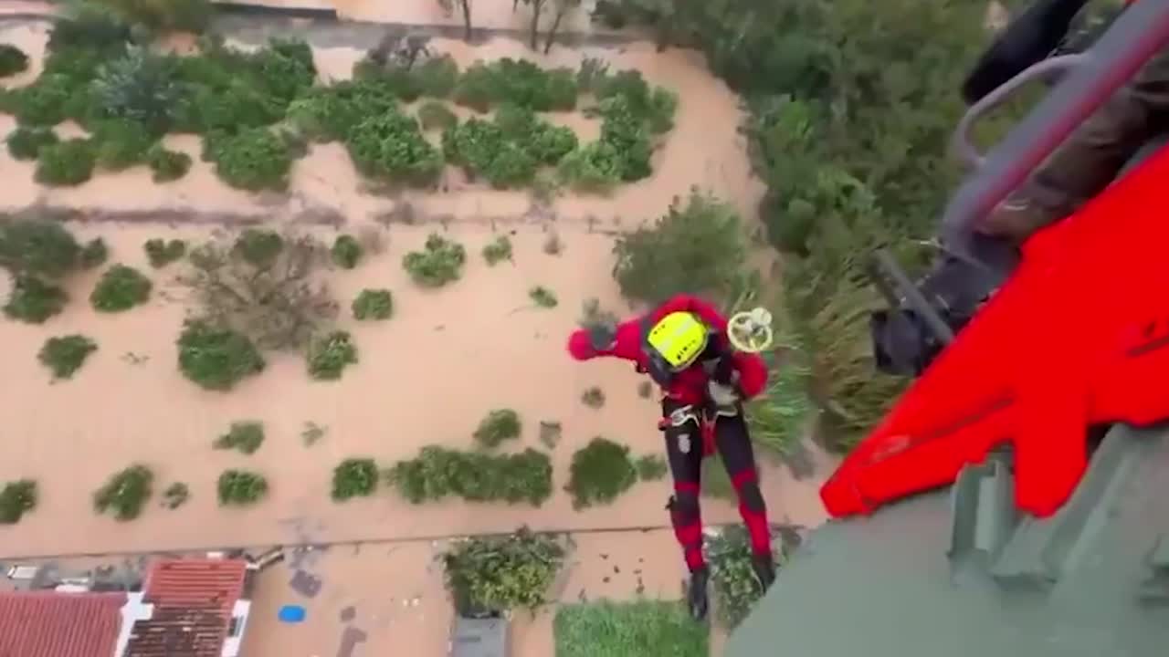 Rescuers winched from helicopters to save people trapped by floods in Spain