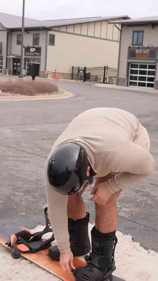 Trying a dangerous snowboarding stunt over a luxury car