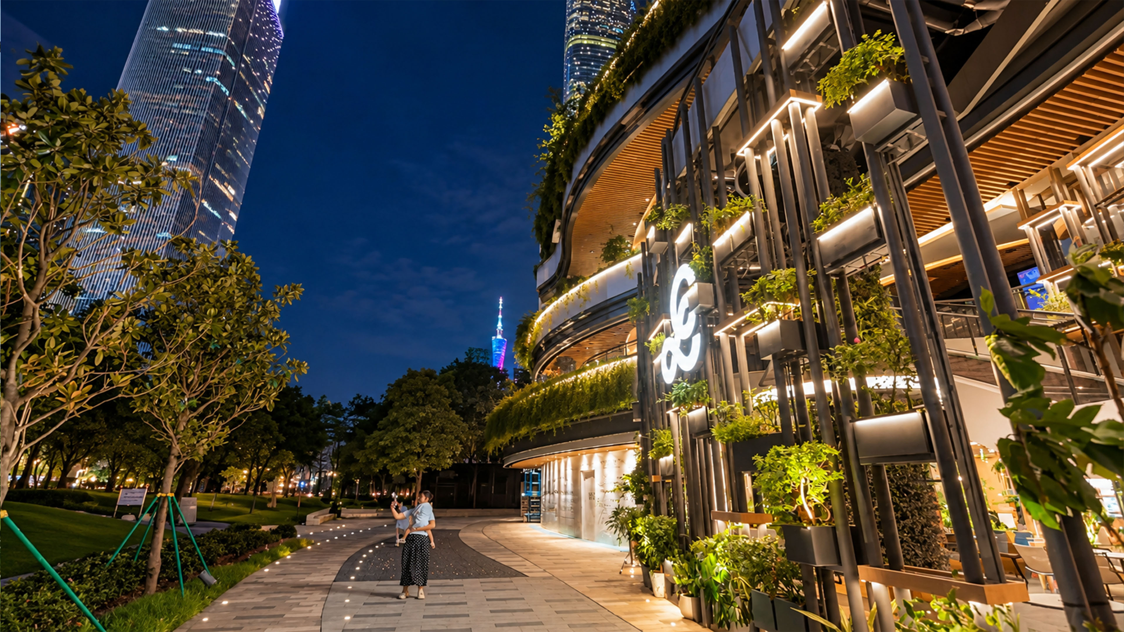 Curved building covered in greenery stands among Guangzhou's skyscrapers