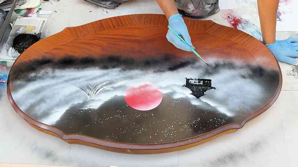 A Rome street artist spray paints my table with a Japanese design