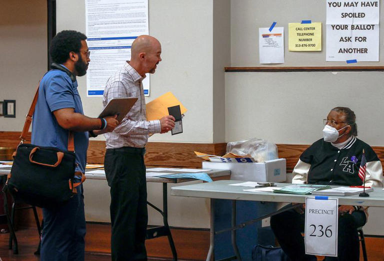 FILE PHOTO: A U.S. Department of Justice (DOJ) poll watcher shows his badge to a polling station worker during the Michigan primary elections, in Detroit, Michigan, U.S., August 4, 2026. REUTERS/Rebecca Cook/File Photo