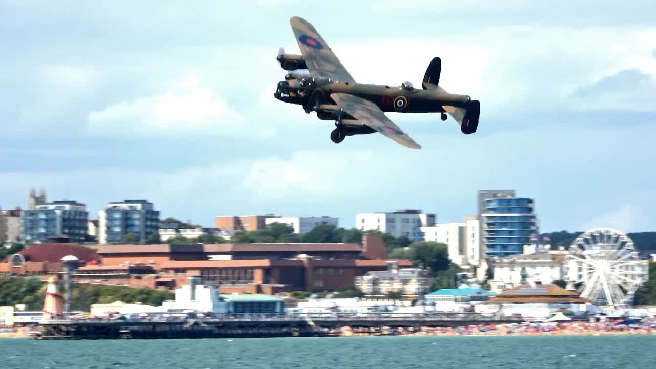 Lancaster bomber makes a low coastal flypast - watch how close it comes ...