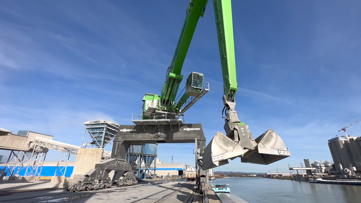 Giant port material handler with clamshell grab at industrial harbor