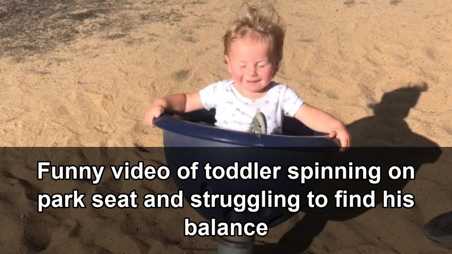 Dizzy little boy wobbles after dad lifts him off a spinning playground seat