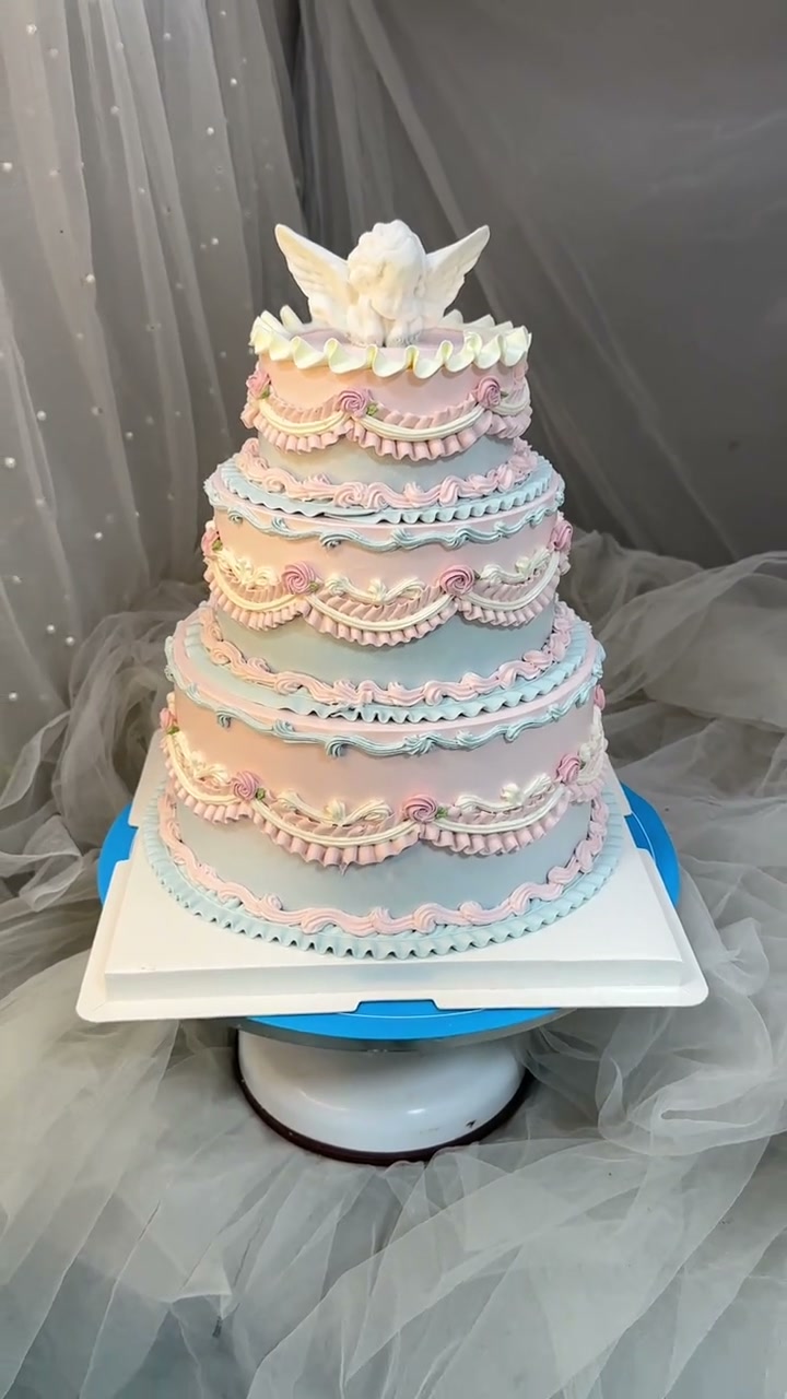 Angel-crowned pastel rainbow tiered cake is a vintage dream