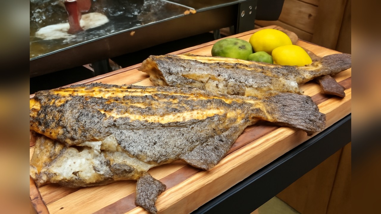 Fresh fluke fish fries in butter on a Blackstone flat top