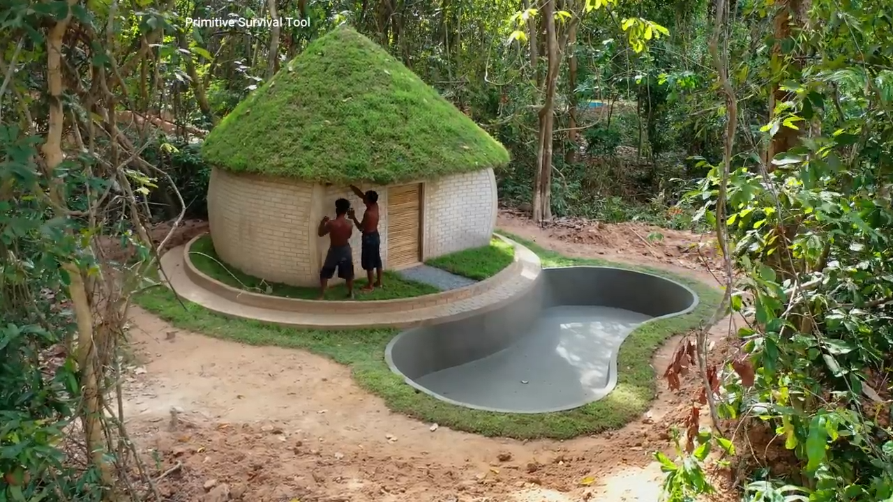Builders shape a custom pool for a hobbit house with a grass roof