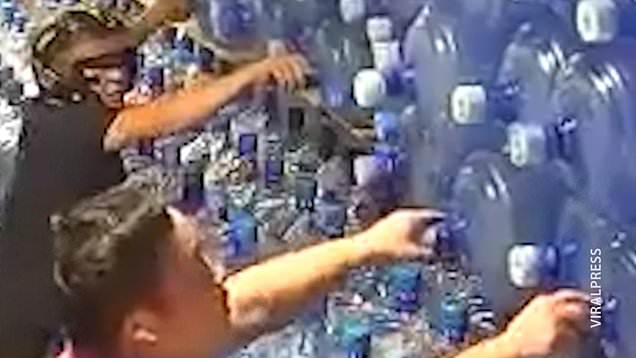 Workers trigger giant water bottle stack to collapse