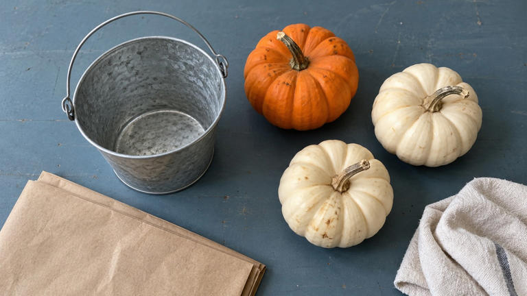 How can mini pumpkins brighten a simple metal bucket?