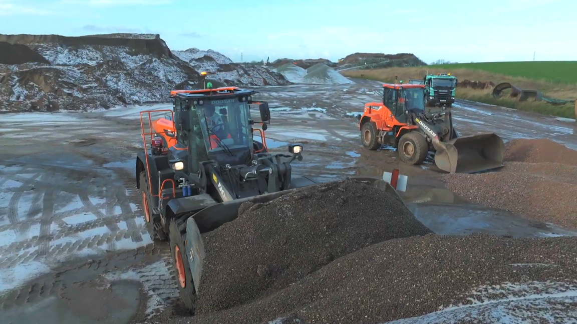 Wheel loaders loading and moving gravel at a quarry site