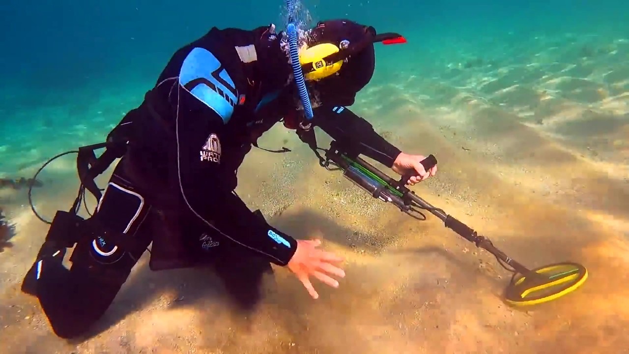 Metal detectorist finds a gold antique ring underwater in an ocean bay