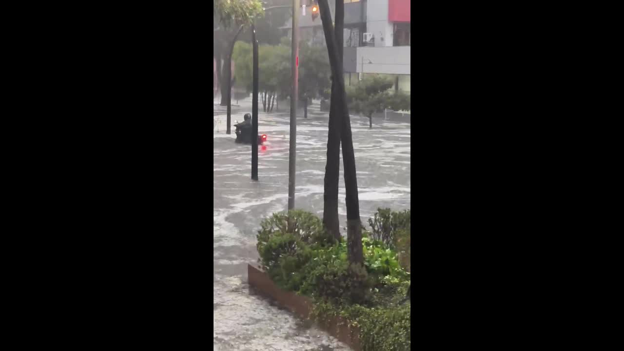 Flash flooding sweeps vehicles through hail-covered streets in Quito ...