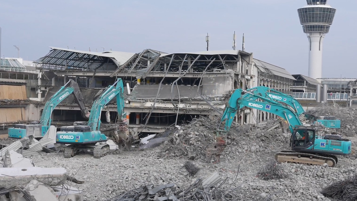 Heavy excavators breaking down concrete structures at an airport