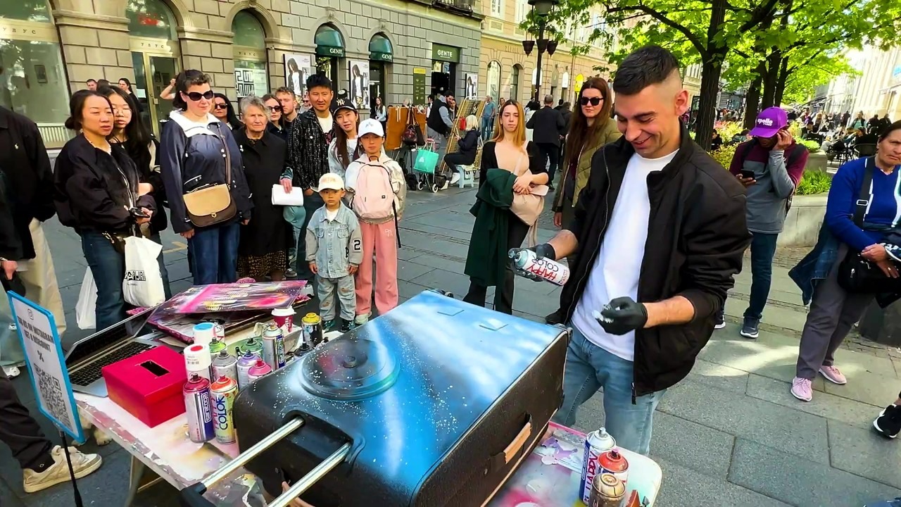 Street artist spray paints old New York on a luxury suitcase