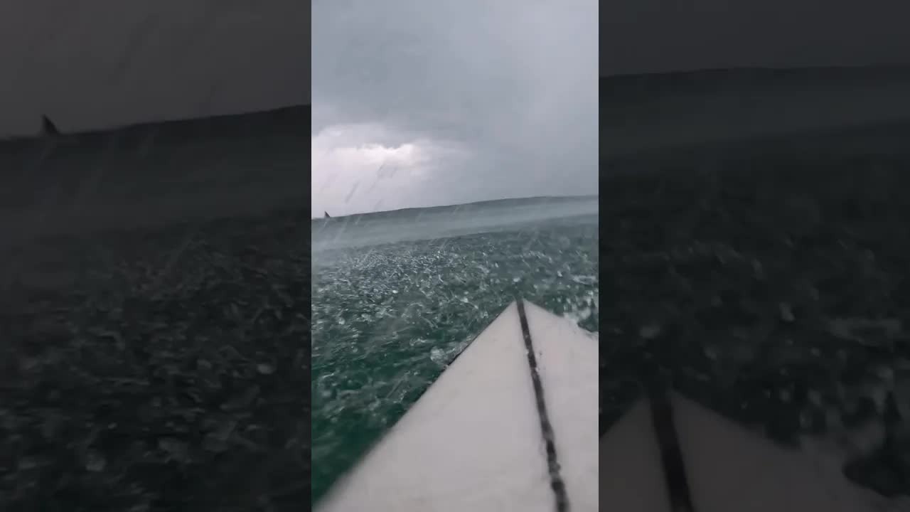 Surfers ride waves created by a cyclone