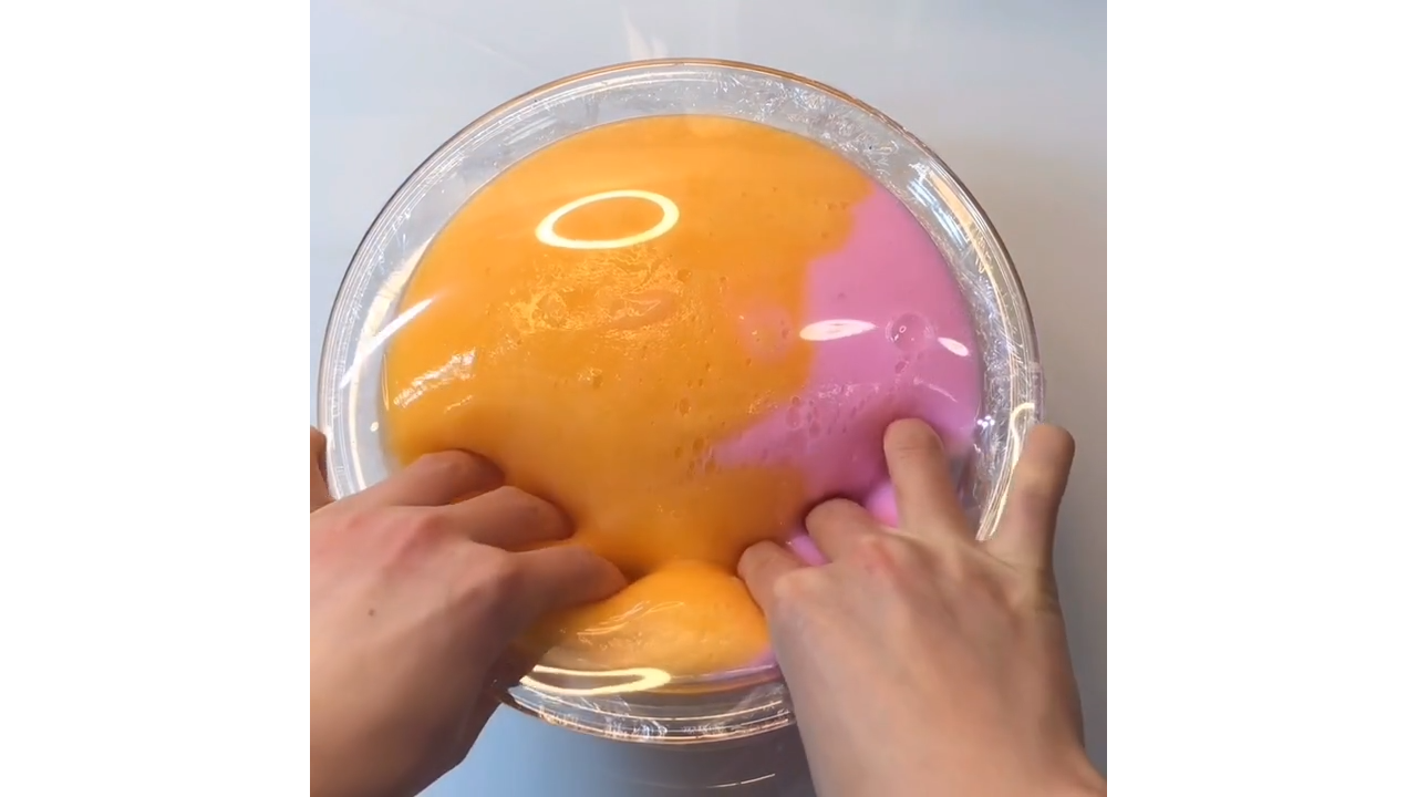 Poking orange and pink slime creating satisfying colorful bubble pops