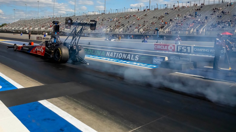 What do they lay down on drag tracks to make the surface so sticky?