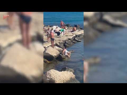 Woman slips on rocks and falls face-first into water