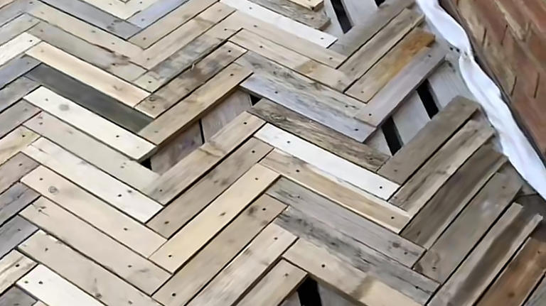 Woman replaces concrete slabs with old wood pallets for a DIY deck with ...