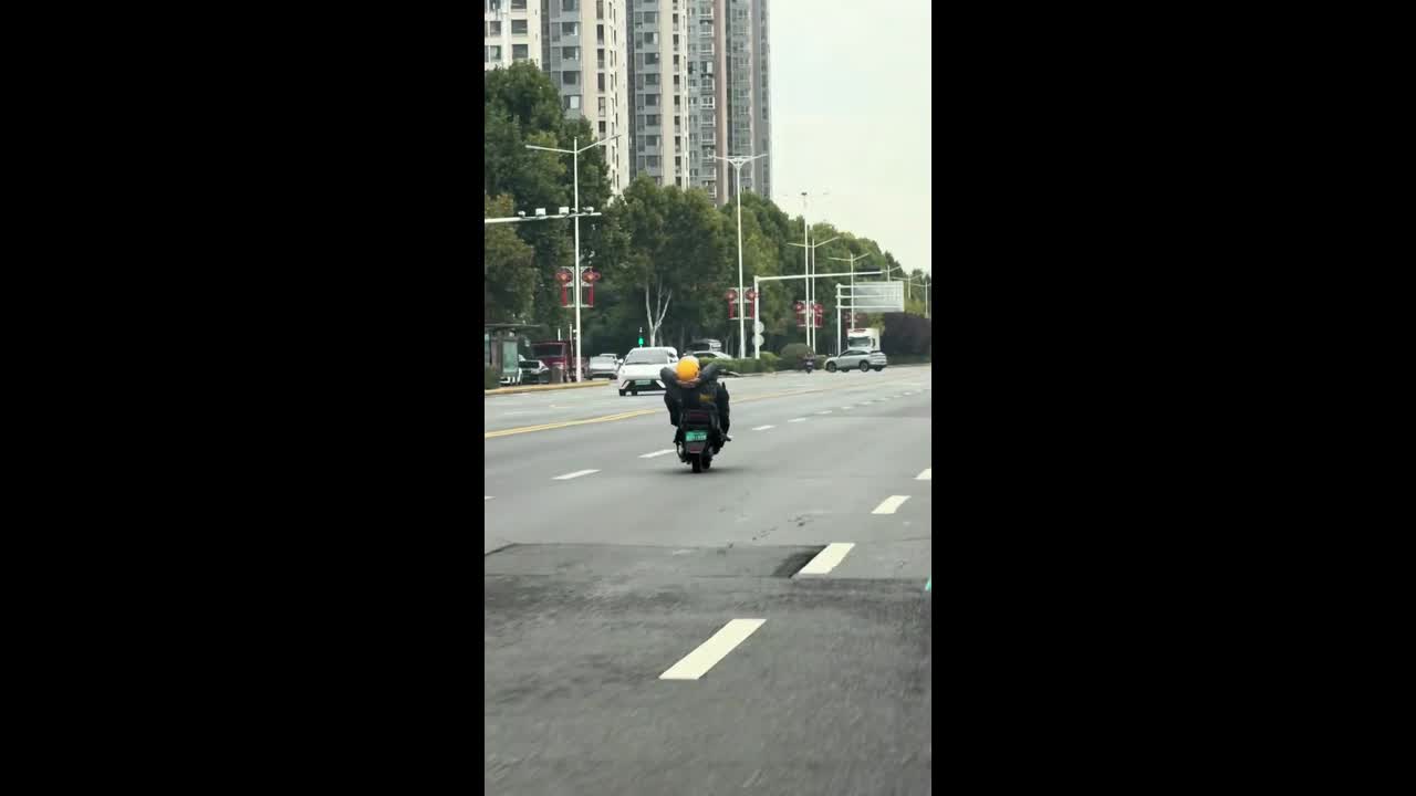 Meituan rider spotted riding a motorcycle in a reclined position on a ...