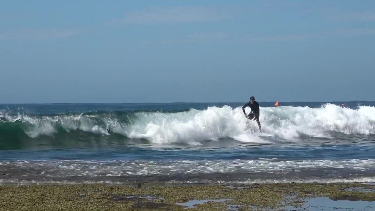 Surfer launches above the wave in raw beach session