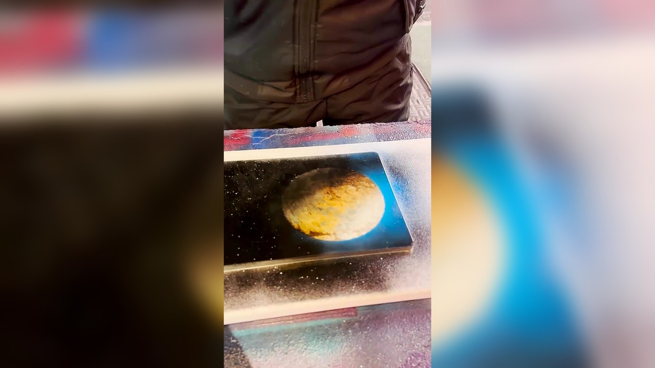 A woman tests Mr. Spray's spray painting skills