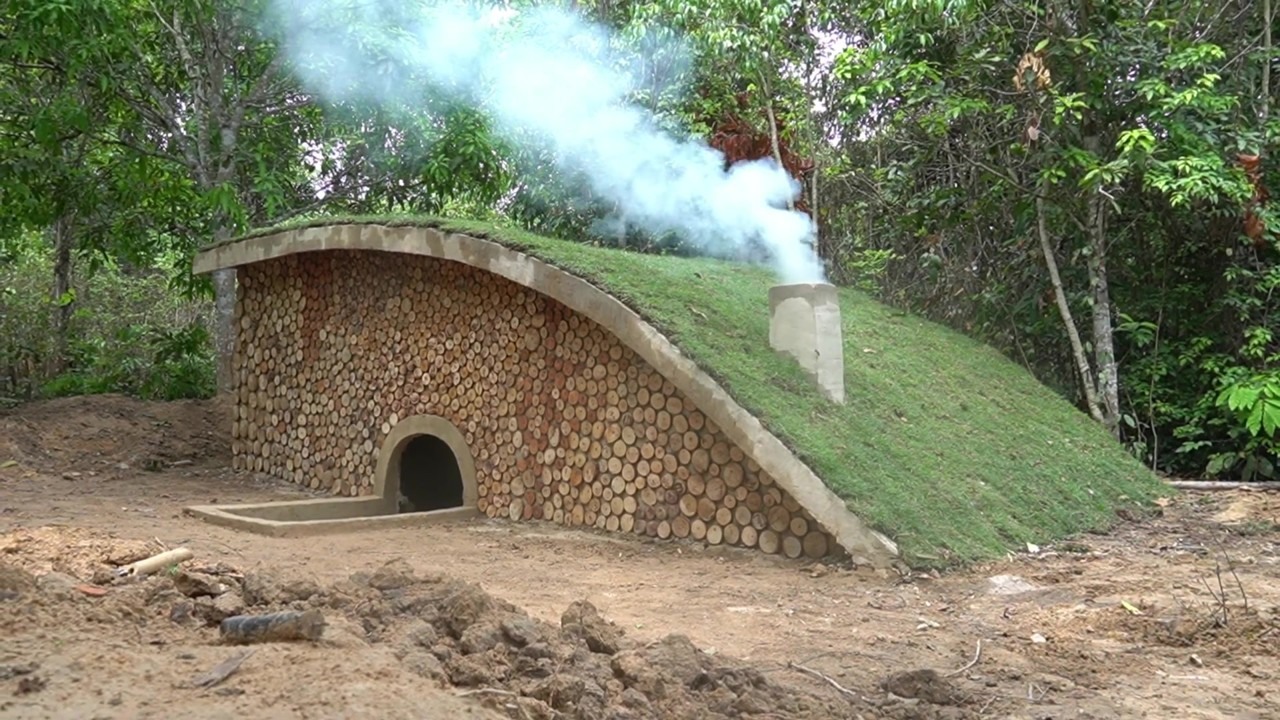 Underground woodland house with a grass-covered roof