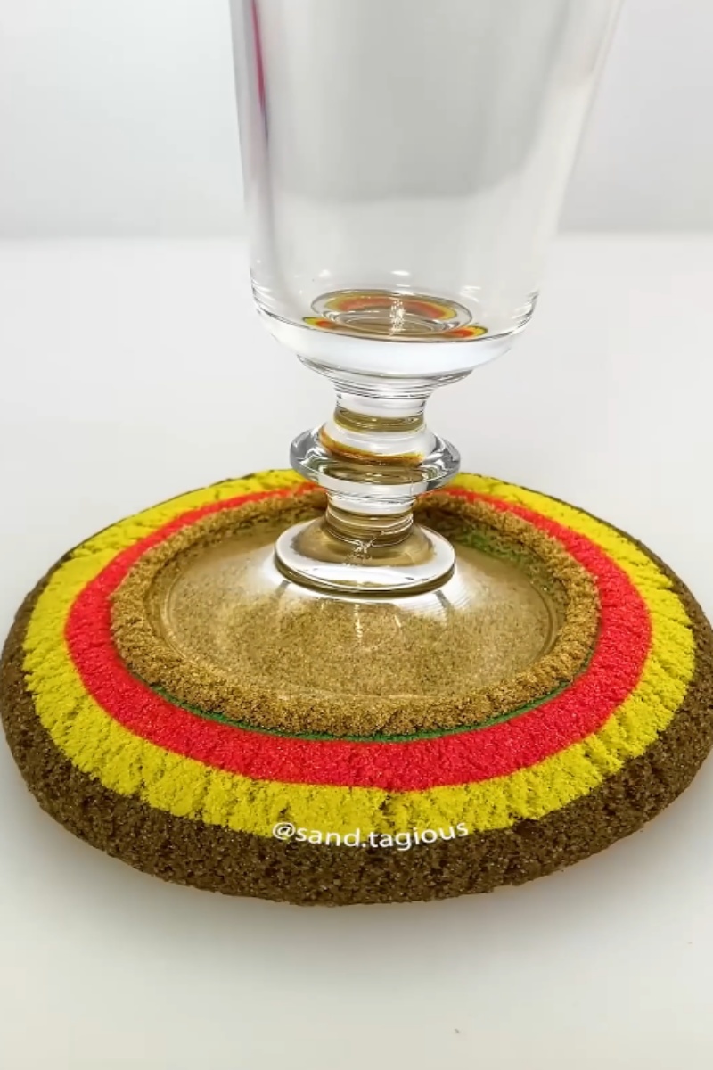 Beautiful rainbow sand art with a glass