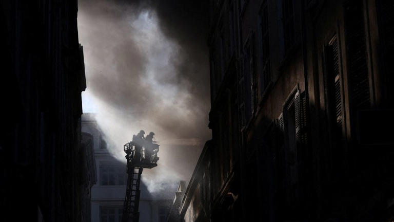 French firefighters on Saturday work to extinguish a blaze in a building amid protests in Marseille. - Manon Cruz/Reuters
