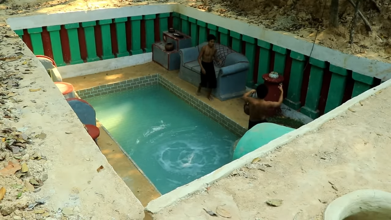 Builders dig into solid ground to make a cave pool and living room