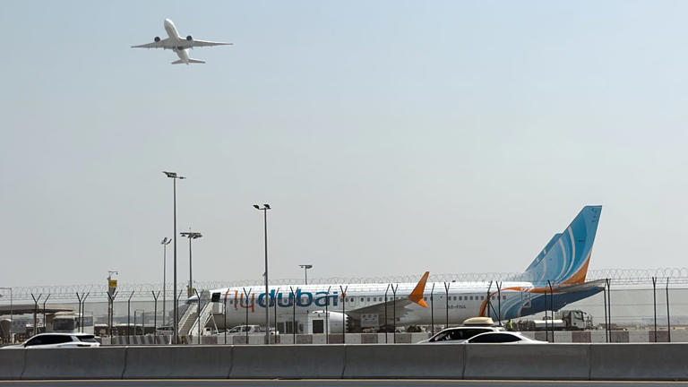 An aircraft takes off as a Flydubai plane sits on the tarmac at Dubai International Airport, United Arab Emirates, 30 September 2026.