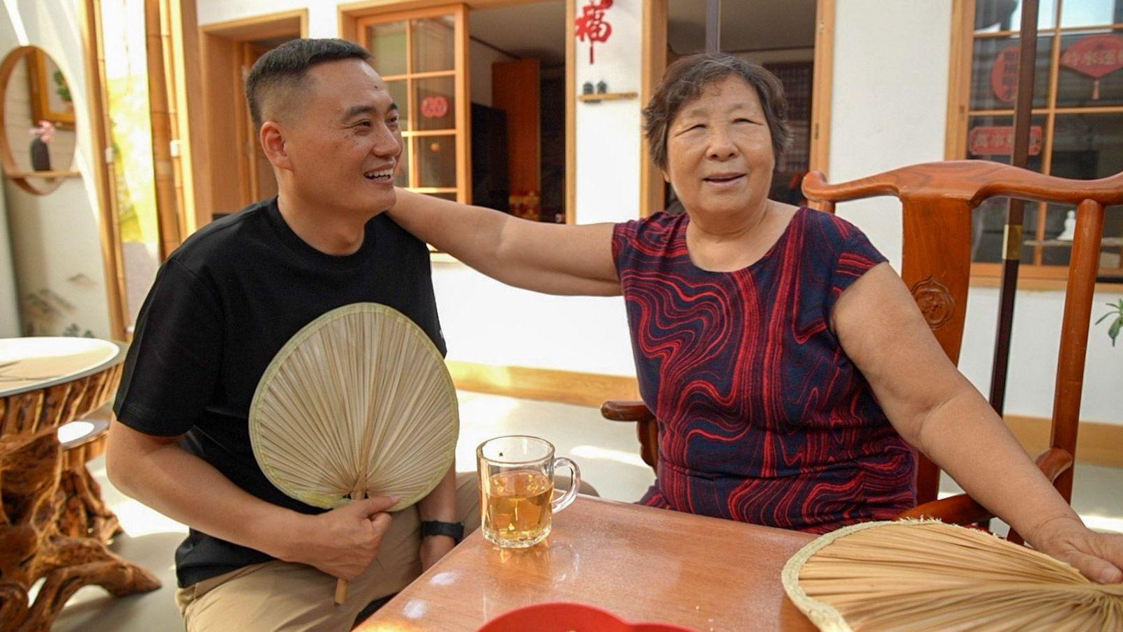Zheng Ruizhi, de 75 años, comparte un momento distendido con Wang Yingwei durante una visita a su domicilio.