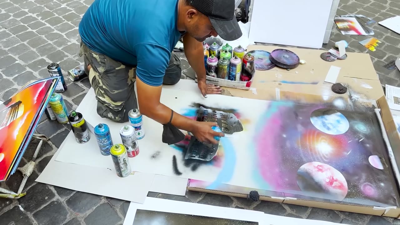 Street artist spray paints curtains with a floating Colosseum