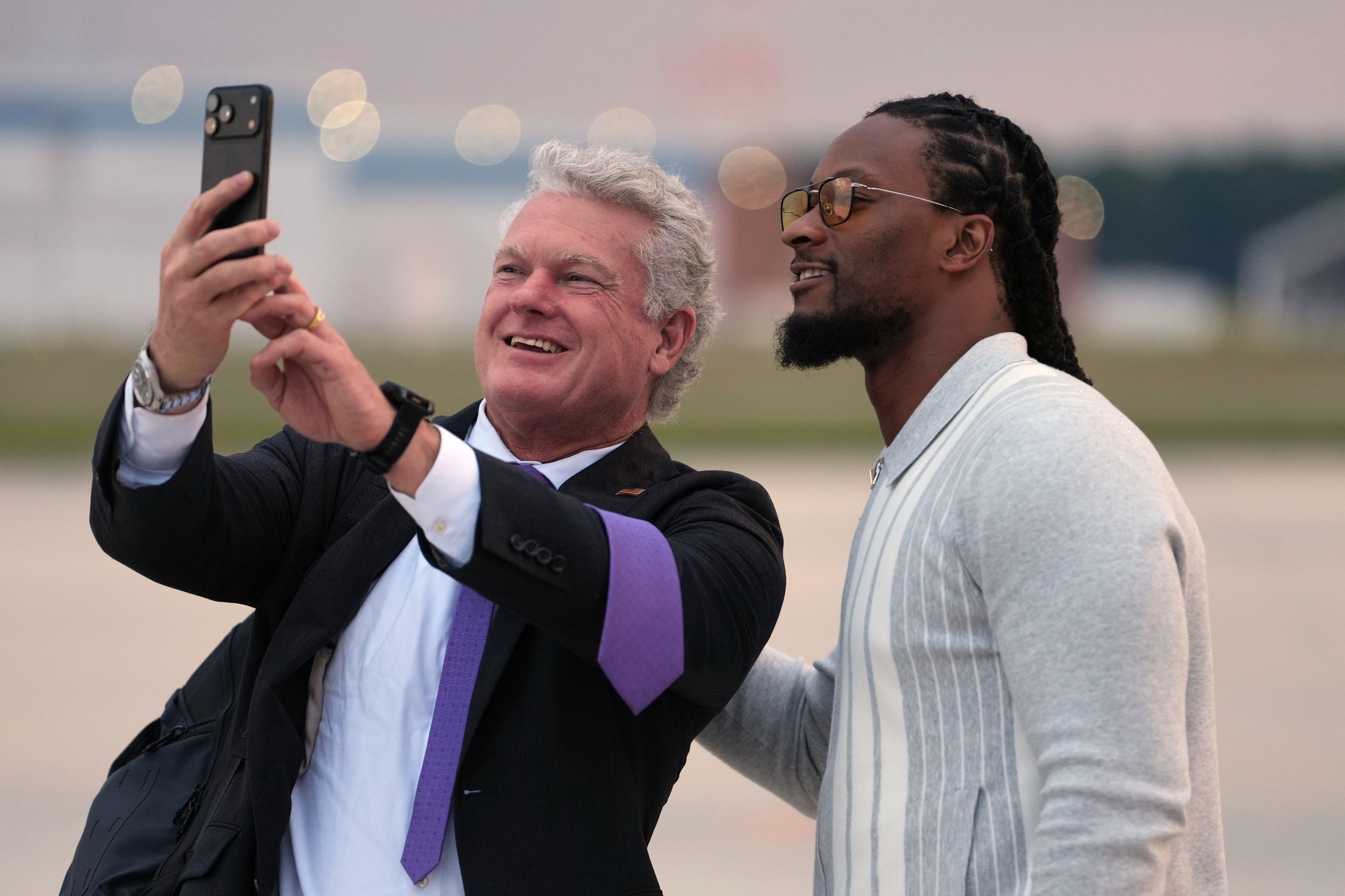 Georgia U.S. Senate candidate Rep. Mike Collins, R-Ga., takes a photo with Todd Gurley before President Donald Trump boards Air Force One, Friday, Oct. 16, 2026, at Dobbins Air Reserve Base, Ga. (AP Photo/Mark Schiefelbein)