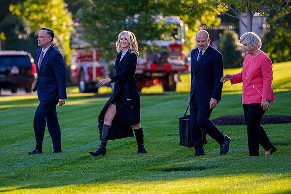 Natalie Harp beams as she boards Marine One in knee high boots