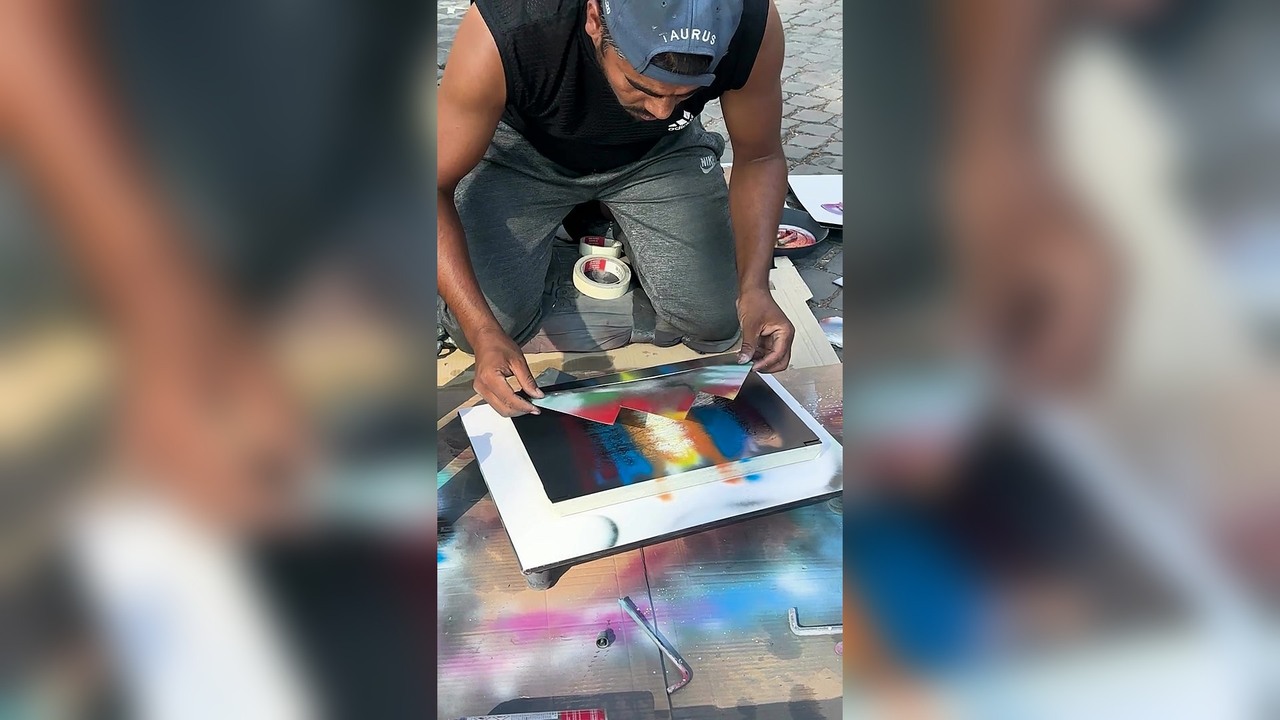 Street artist spray paints a design