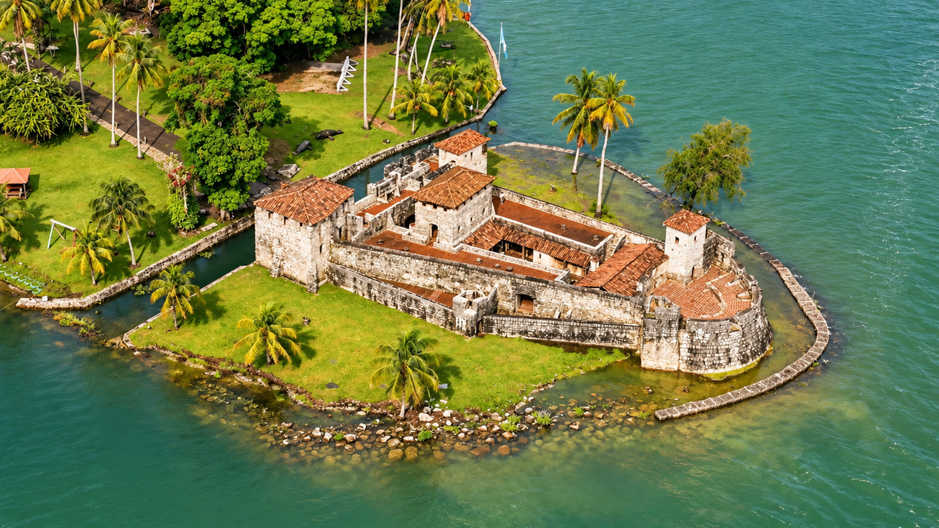 A stone castle standing beside Guatemala's tropical lake